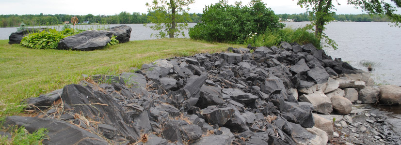 Large boulders stacked high form this lake seawall construction project.