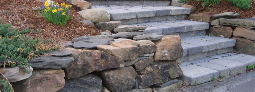 A Vermont stone wall stands upright for this landscape design.